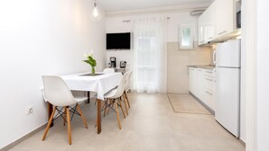 Una cocina moderna con armarios blancos, microondas y refrigerador.