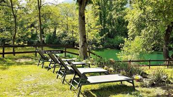 A serene outdoor area with wooden benches and a sign reading "Vidourle."