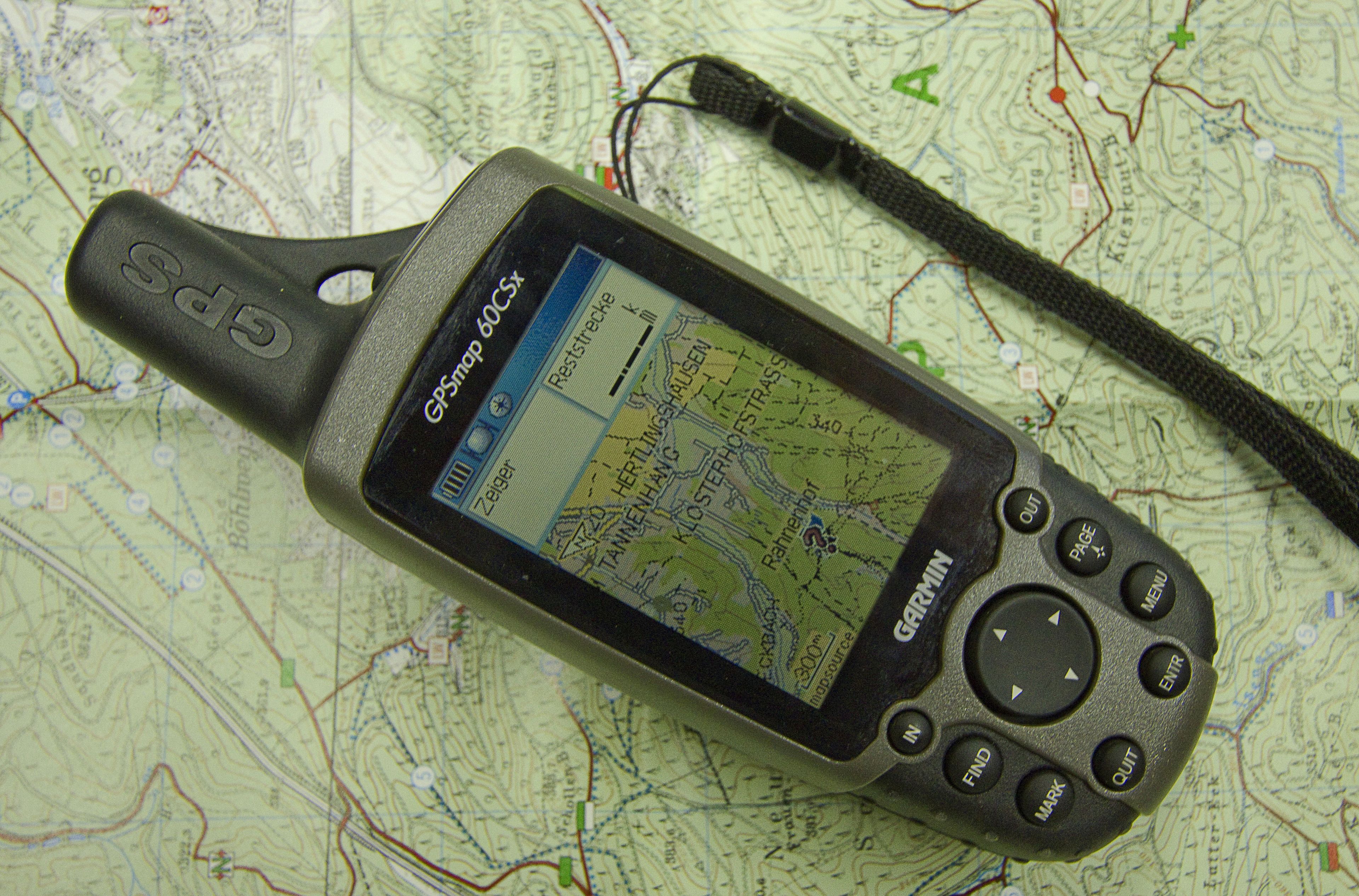 Un appareil GPS doté d’un écran affichant une carte, d’une sangle et d’un écran secondaire présentant une carte avec différentes indications.