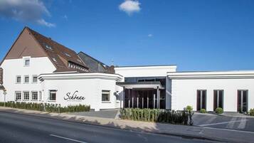 A hotel with a modern design, featuring a prominent entrance and a sign that reads "Schloss."