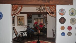Een eethoek met een ronde tafel, stoelen en een rood tapijtendecor.
