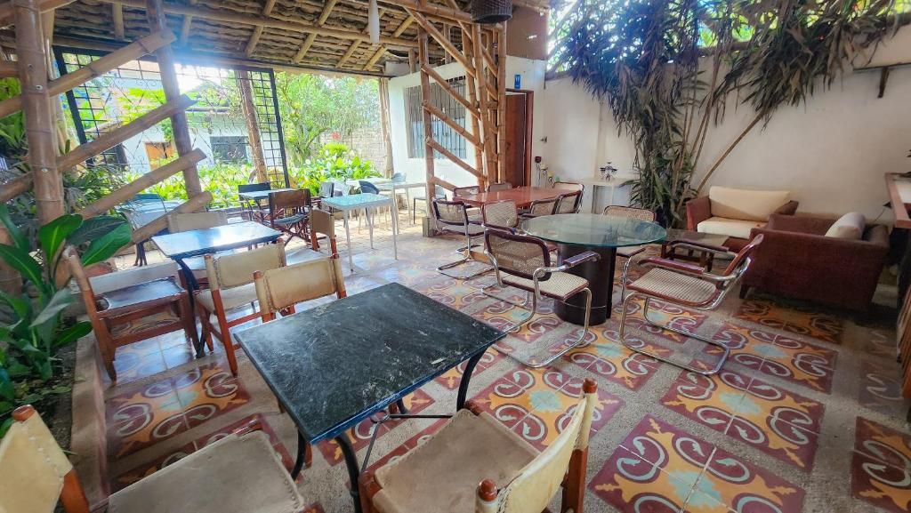 An indoor seating area with tables and chairs, a patterned floor, and a wooden ceiling structure.
