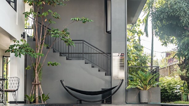 A modern building with a clear glass pool reflecting its structure. - iSilver Hotel (Chiang Mai)
