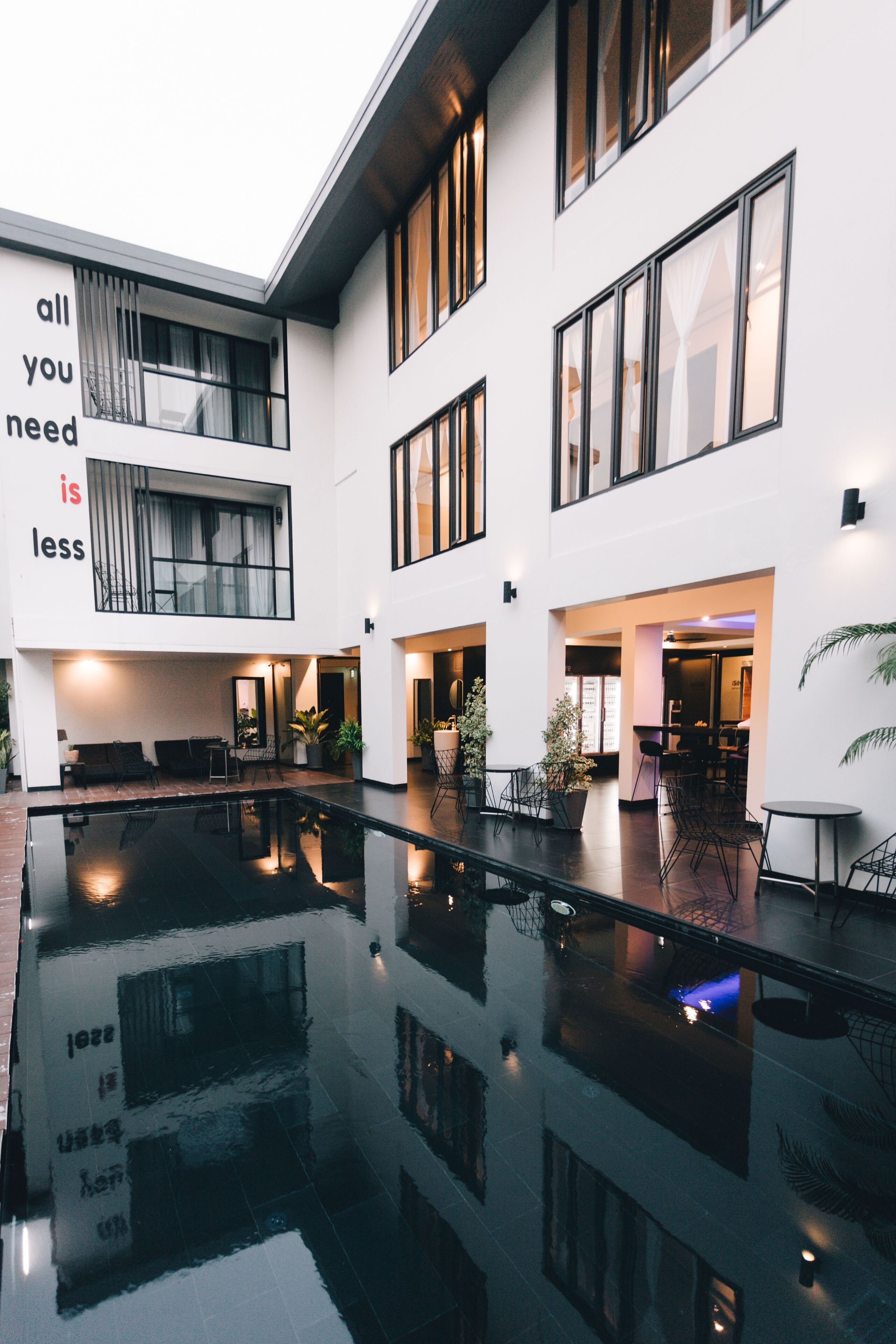 A modern building with a reflective pool, large windows, and a minimalist design.