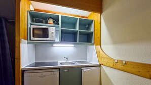 Eine kleine Küche mit Mikrowelle, Spüle und Geschirrspüler.