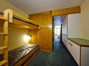 A bunk bed room with a desk and a chair, wooden walls, and a hallway leading to another room. - Studio for 5 people ski-in/ski-out in Charvet, Arc 1800 (Les Arcs 1800)