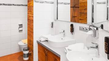 Un baño moderno con inodoro, bidé y dos lavamanos.