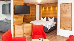 Een kleine hotelkamer met een bed, een televisie, een bureau en een kledingkast.