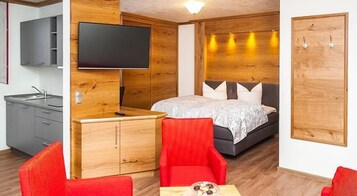 Quarto de hotel compacto com cama, televisão, escrivaninha e guarda-roupa.