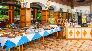 Een buffetopstelling met diverse gerechten, een koffiehoek en een zichtbaar menubord.