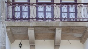 A building with a two-story balcony with metal railings and three windows on the ground floor. - Liiiving In Porto - Downtown Luxury Apartment 3R (Porto)