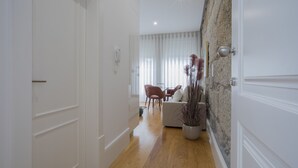 A hallway with a dining area, a sofa, and a potted plant. - Liiiving In Porto - Downtown Luxury Apartment 3R (Porto)