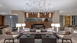 Una sala de estar moderna con chimenea, dos sillones, un sofá y una mesa de centro.