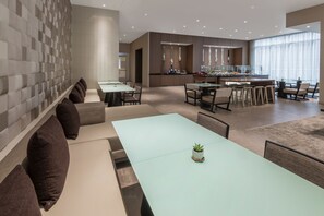 A modern dining area with a light blue table, dark brown chairs, and a small potted plant. - AC Hotel by Marriott Atlanta Midtown (Atlanta)