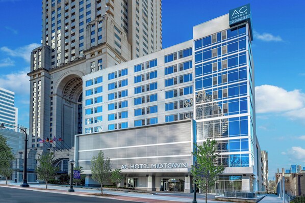 Un hotel moderno con una entrada destacada, ventanas amplias y una vista despejada del horizonte urbano circundante.