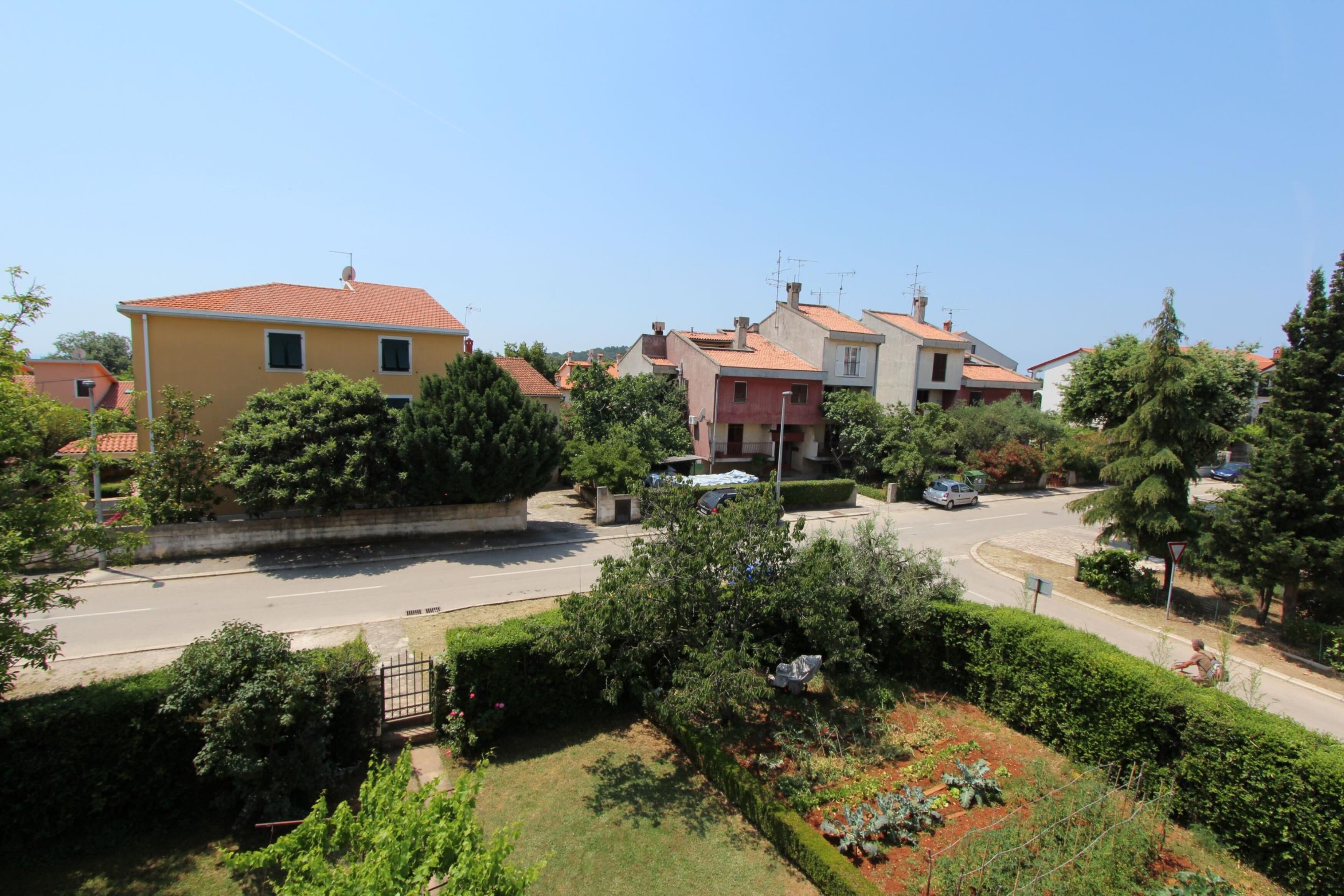 A residential area with houses, a road, and greenery.