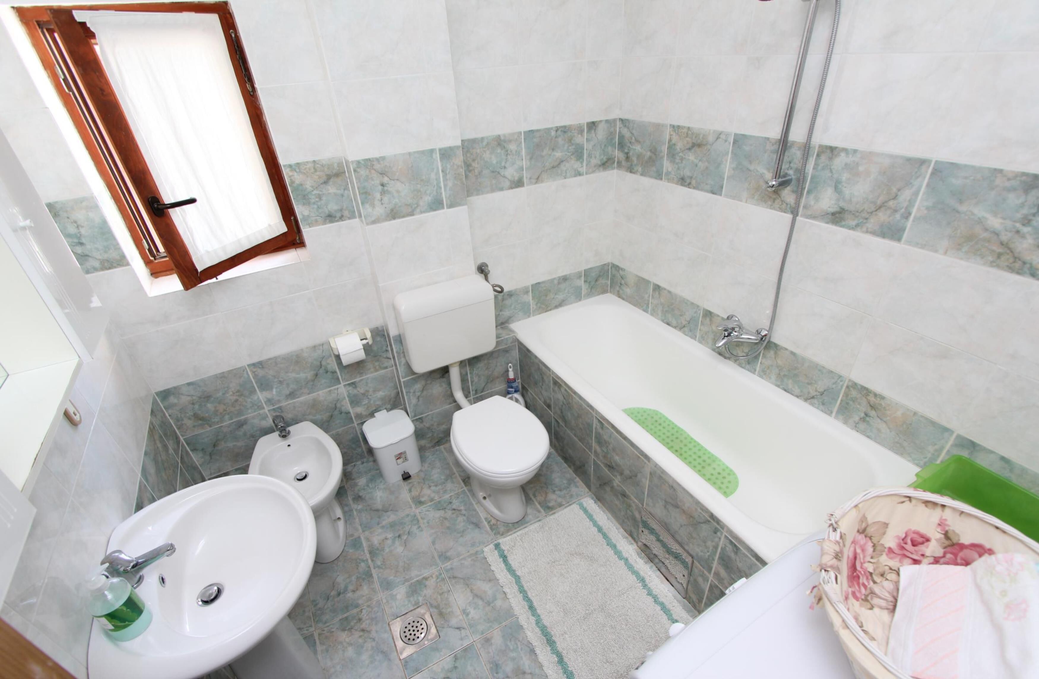 A bathroom with a sink, toilet, bidet, and bathtub.