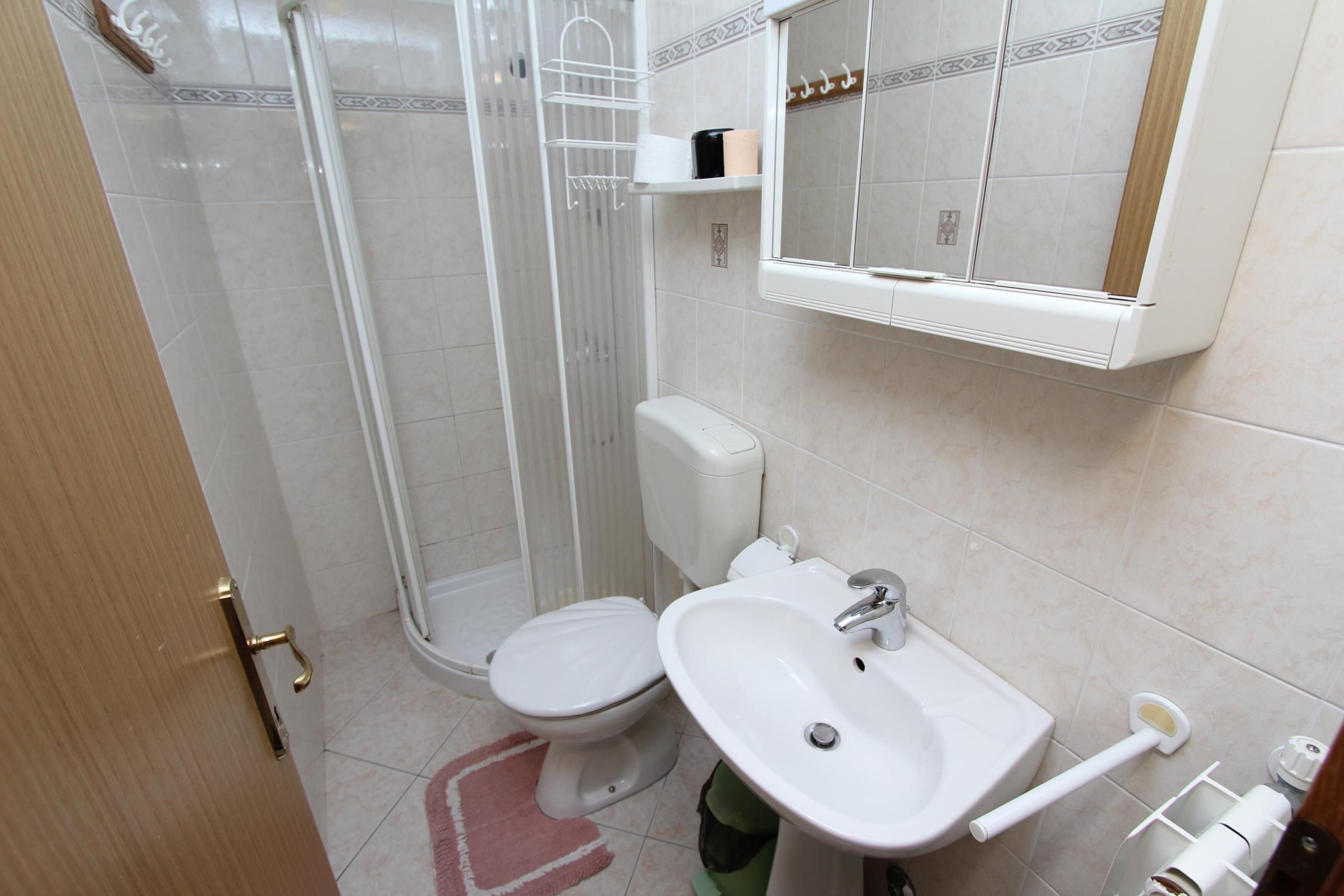 A bathroom with a toilet, sink, and shower.