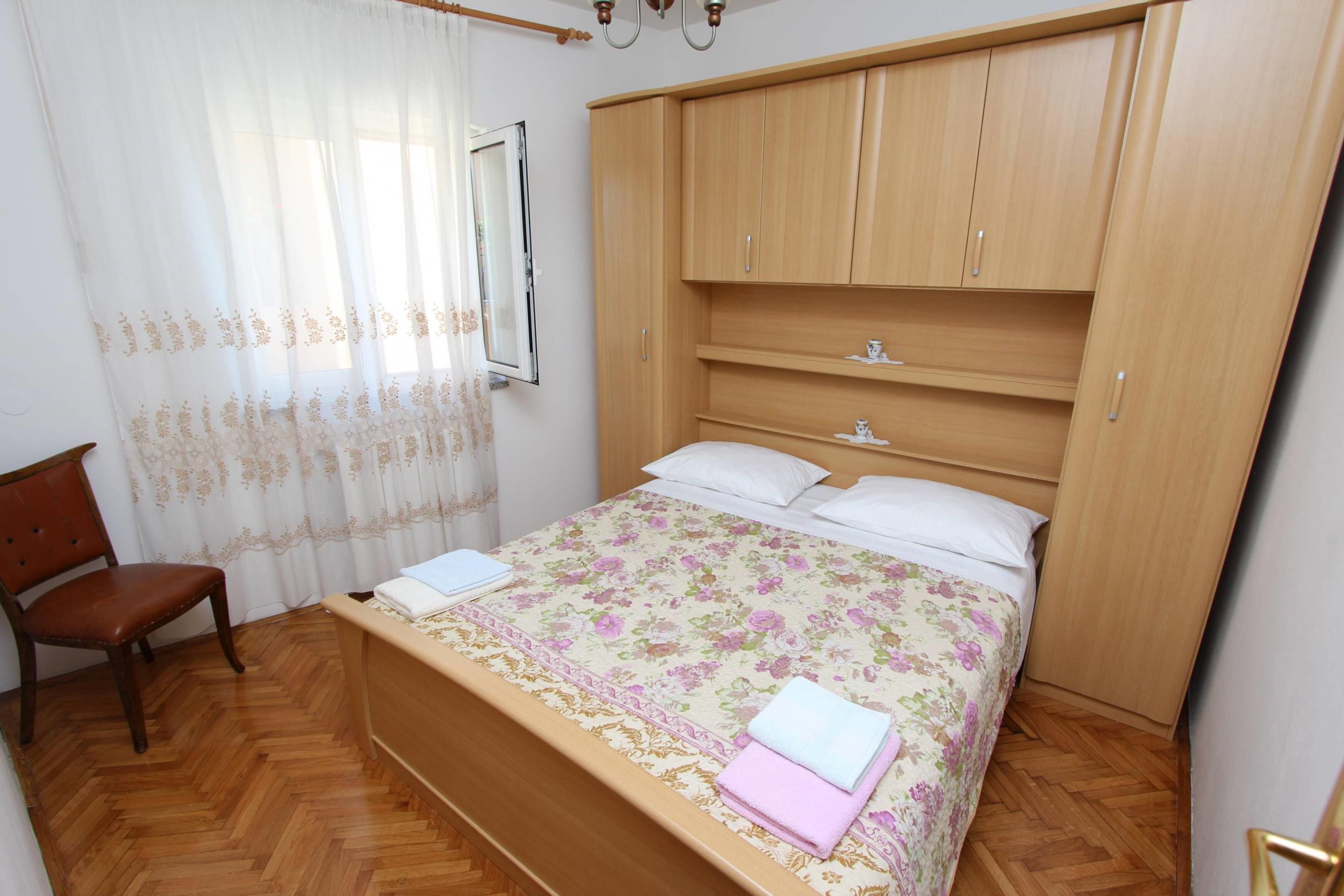 Une chambre à coucher avec un lit en bois, une chaise et une armoire.
