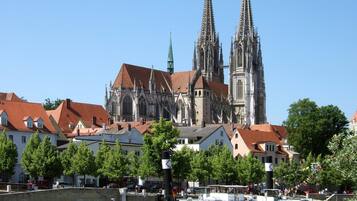 A historic cathedral with twin spires and a riverboat docked in front.