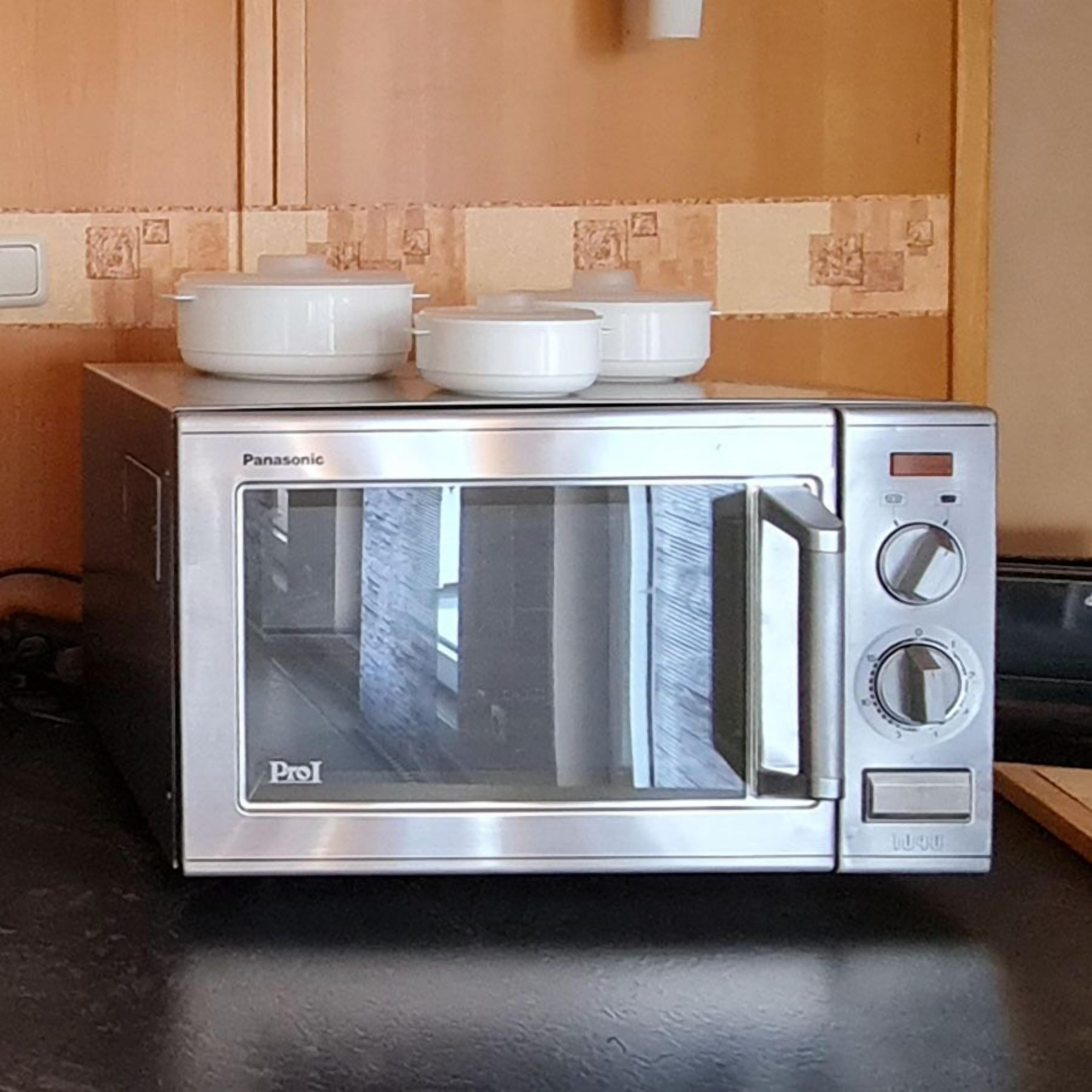 Horno tostador Panasonic con pantalla digital, panel de control y puerta de vidrio.