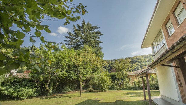 A residential property with a covered patio, a grassy yard, and a large tree. - Residenzadelia (Ronciglione)
