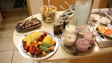 En buffé med ett varierat utbud av mat, inklusive frukt, efterrätter och drycker.