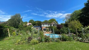 Zona residencial com piscina, vegetação exuberante e casas.