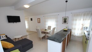 Een modern appartement met een woongedeelte, eethoek en keuken.