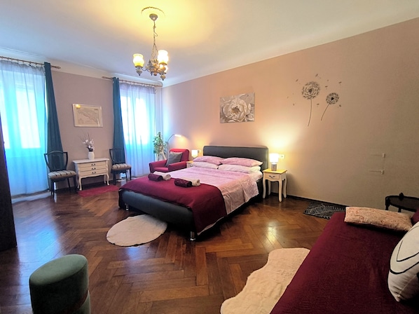 Un dormitorio con cama, escritorio, silla, lámpara y decoración en la pared.