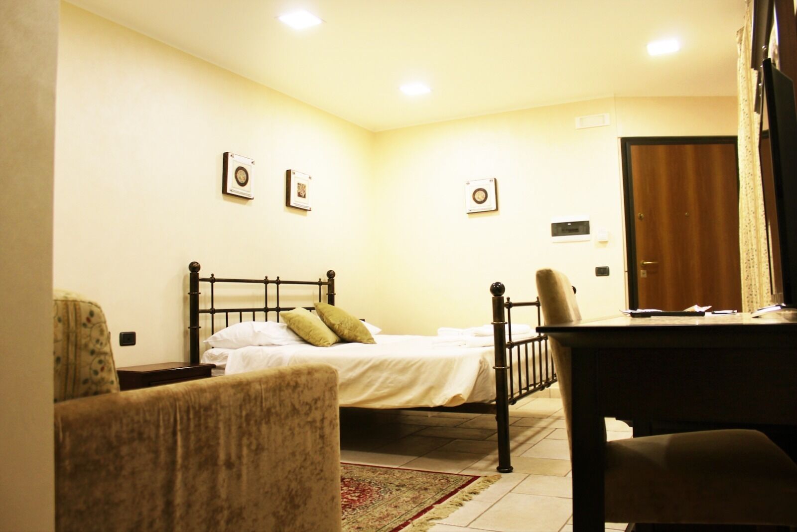 Une chambre à coucher avec un lit, une chaise, un bureau et une porte.