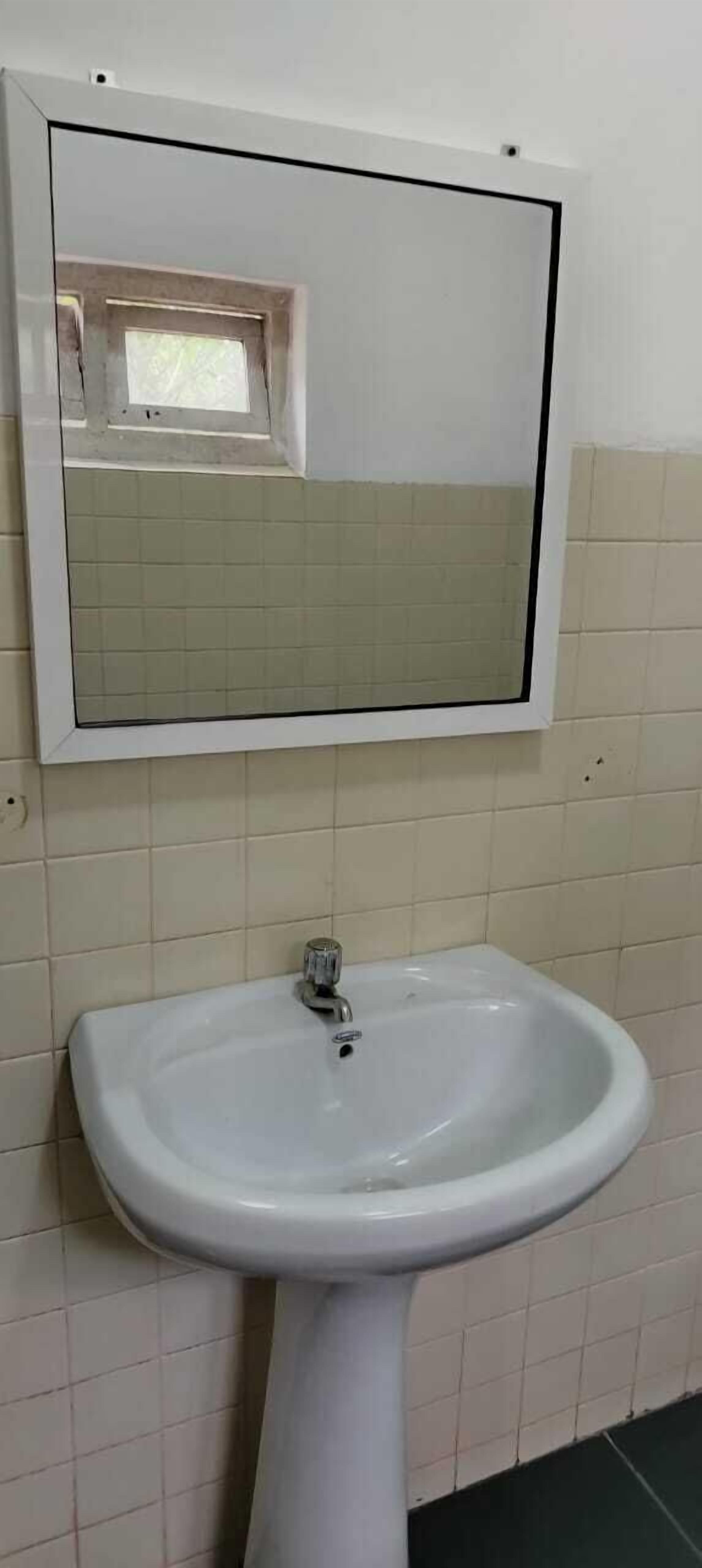 A bathroom with a white sink and a mirror above it.