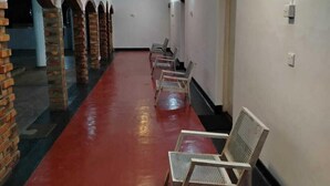 A corridor with red flooring, white walls, and brick arches. - Hotel Lakeside (Anuradhapura)