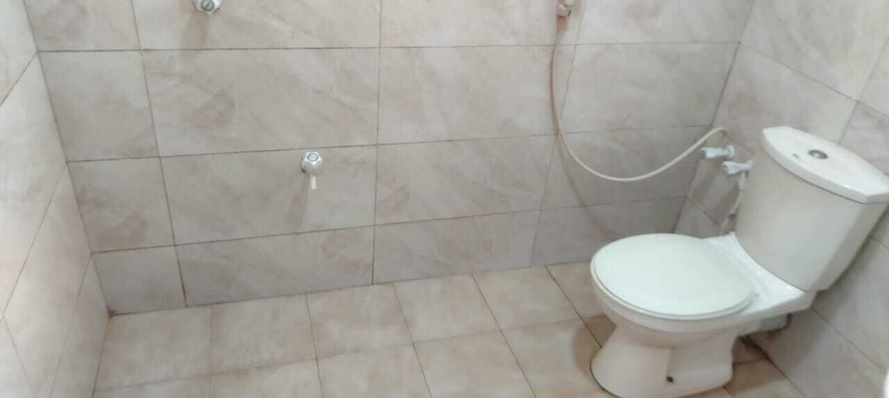 Une salle de bain équipée de toilettes, d’une douche et d’un robinet mural.