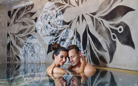 A room with a reflective floor, a wall with a large floral pattern, and a ceiling with a starry design.