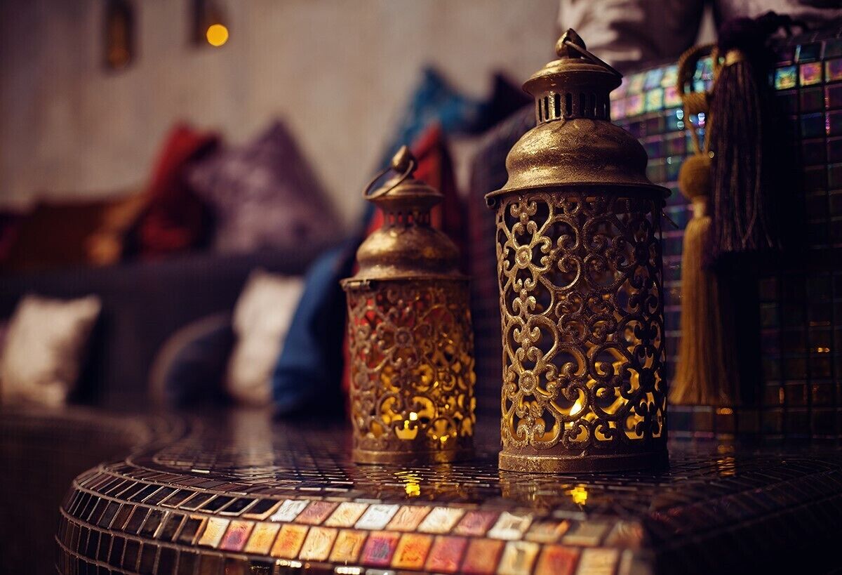Two ornate metal lanterns on a tiled table.