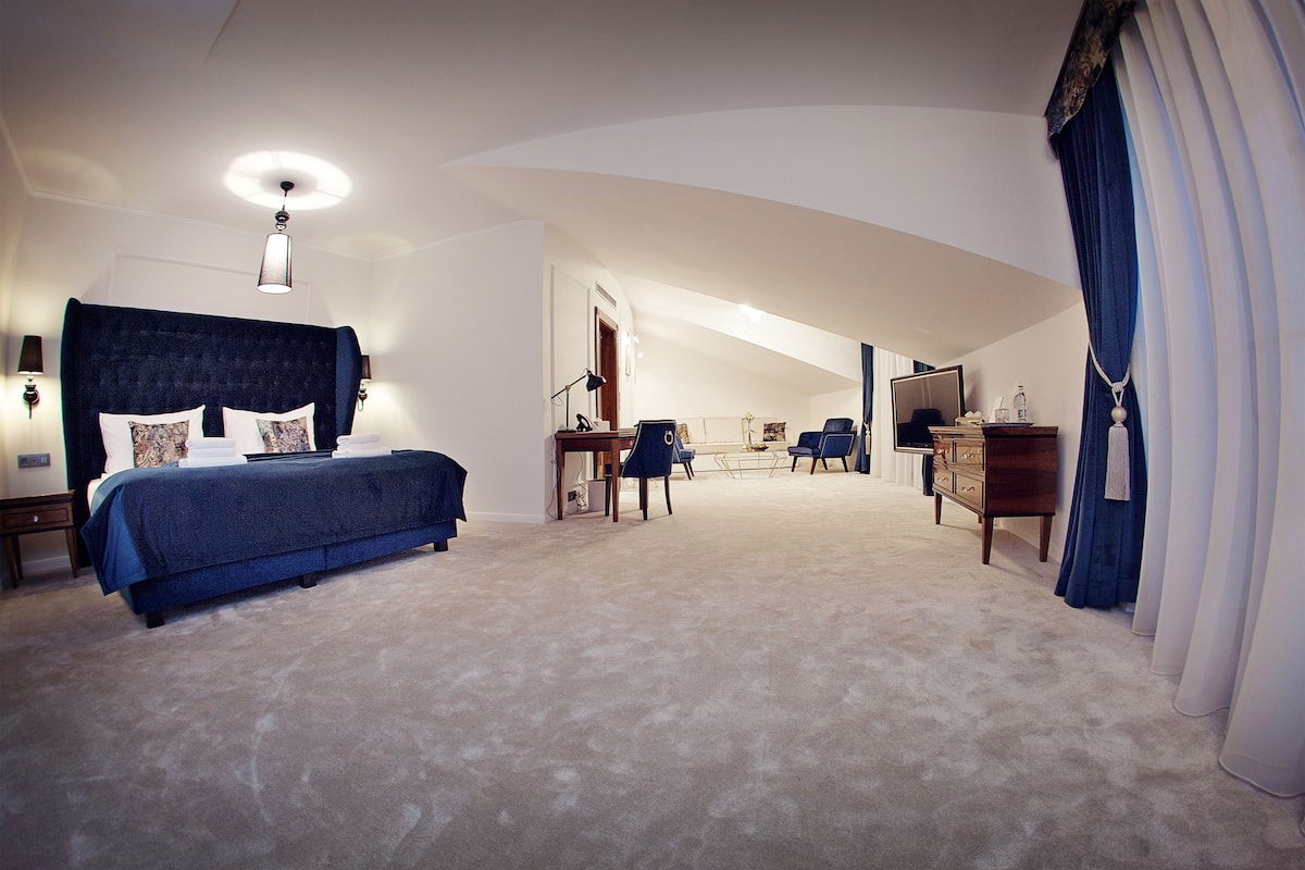 Une chambre d’hôtel spacieuse, dotée d’un grand lit, d’un bureau, d’une commode et d’un téléviseur.