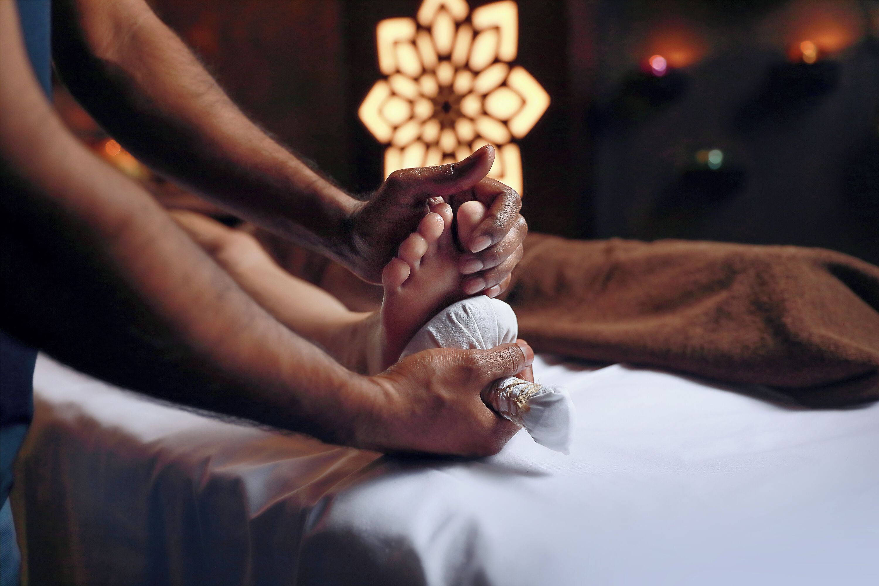 A person receiving a massage with a focus on their hands and feet.