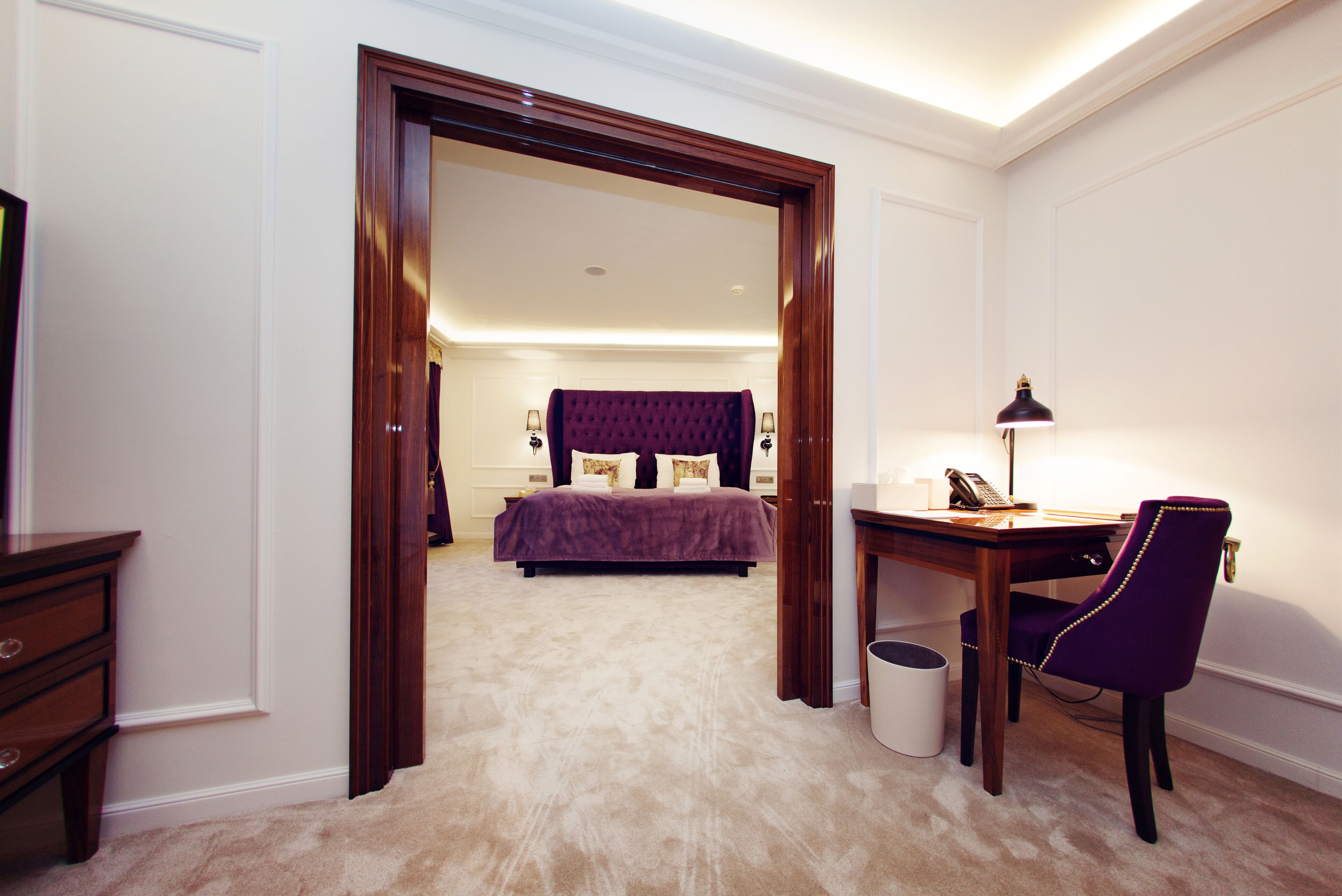 A bedroom with a bed, a desk, and a chair.