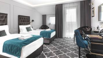 Une chambre d’hôtel avec deux lits, un bureau, une chaise et une grande fenêtre avec des rideaux.