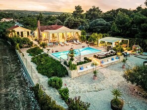 A villa with a swimming pool, outdoor seating, and lush landscaping. - Stunning private villa with private pool, A/C, hot tub, WIFI, TV, terrace and pets allowed (Mirca)