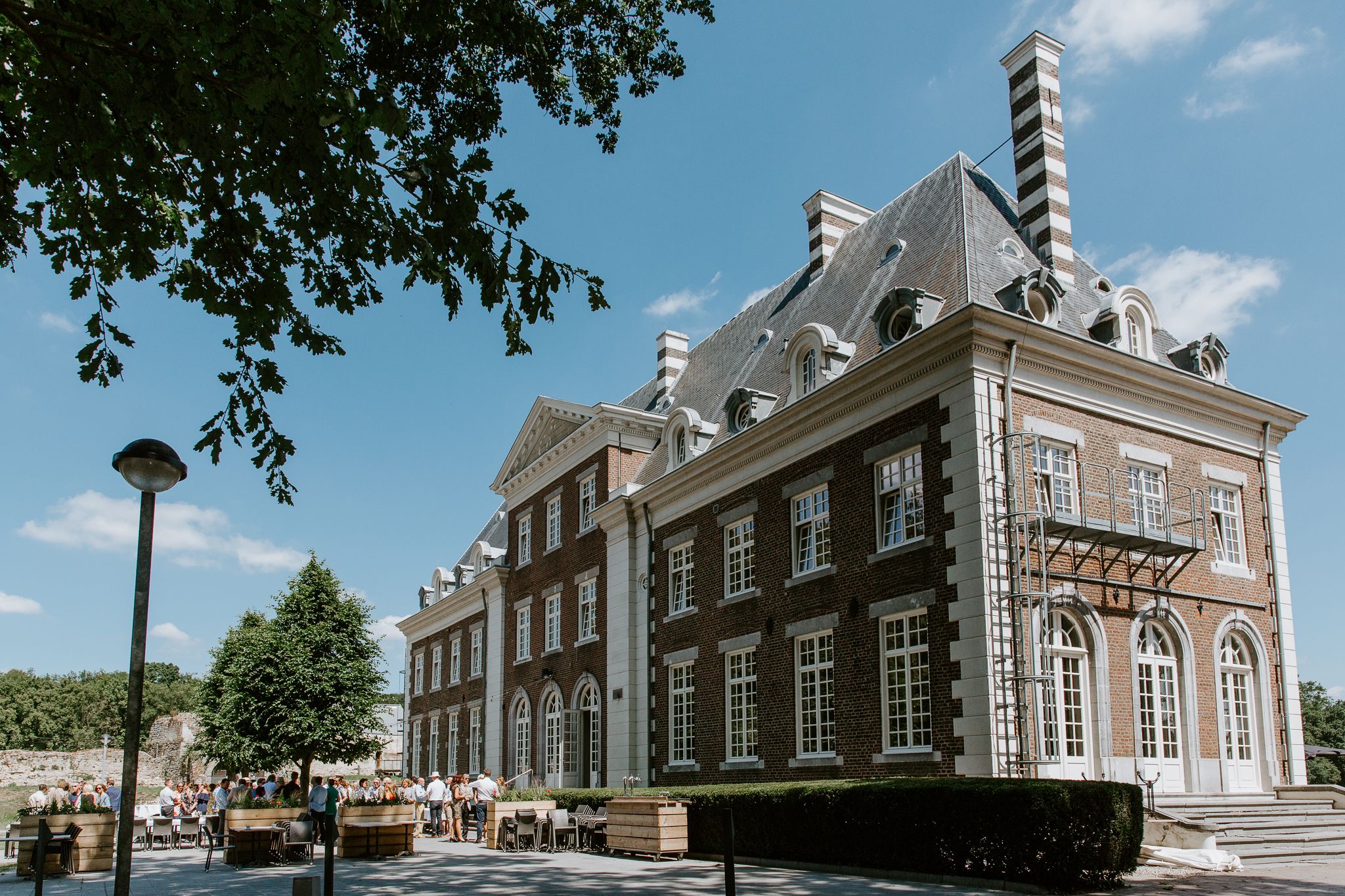 A historic building with a symmetrical facade, large windows, and a prominent chimney.