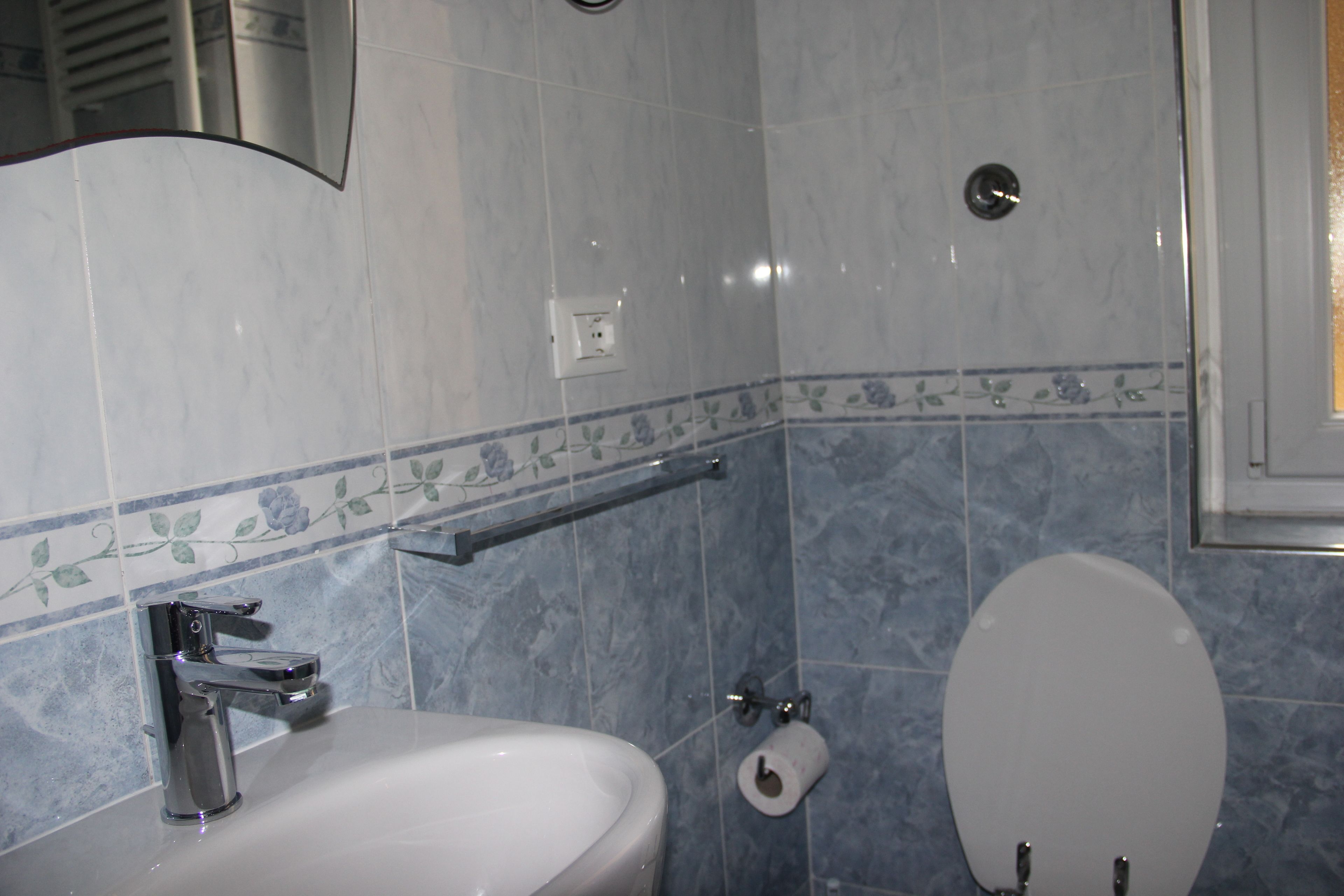 A bathroom with a sink, toilet, and a towel rack.
