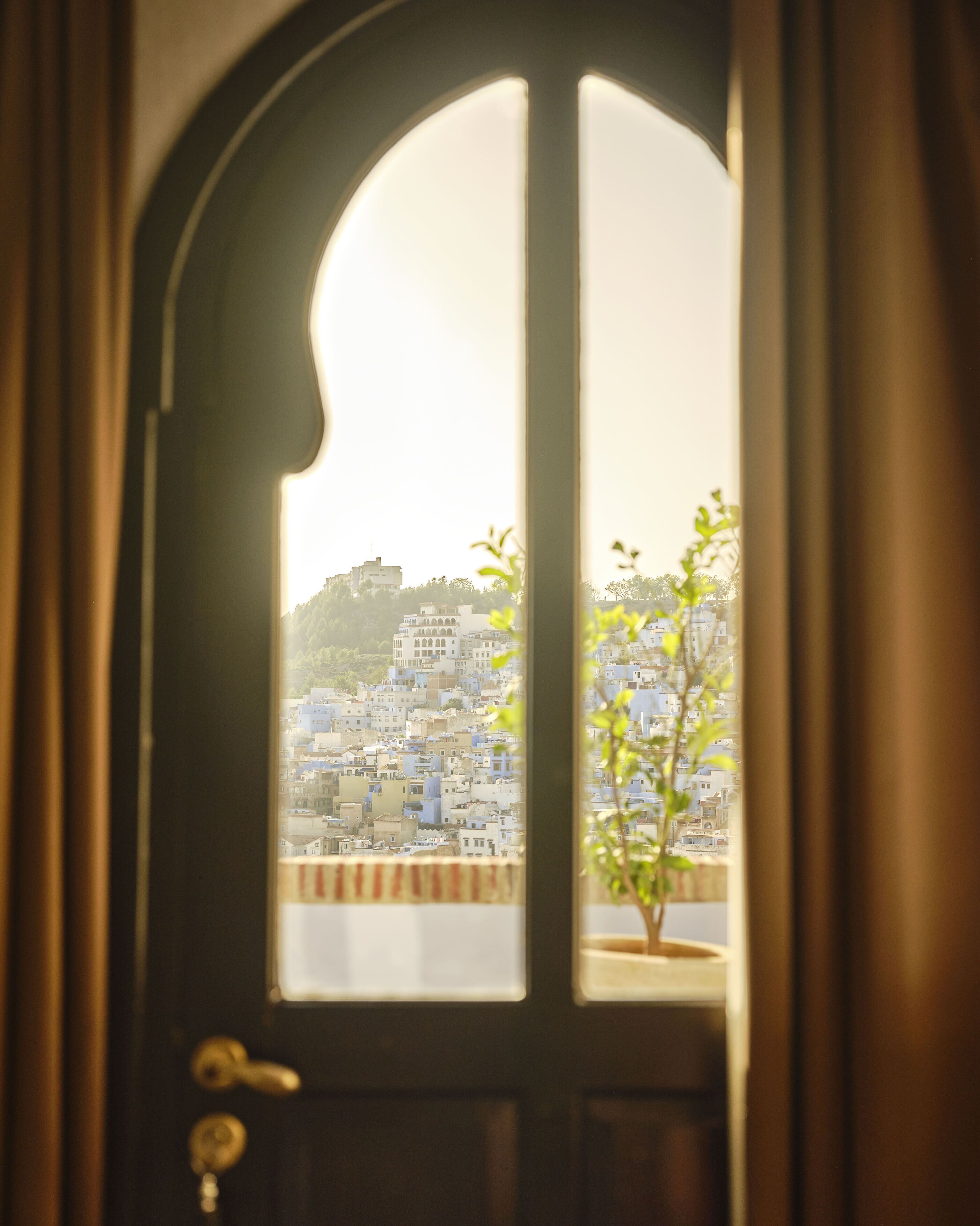 A door with a view of a densely packed cityscape through a window.