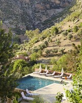 Una piscina al aire libre, sillones reclinables de piscina