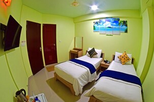 Habitación de hotel con dos camas, televisión, un cuadro y escritorio con teléfono.