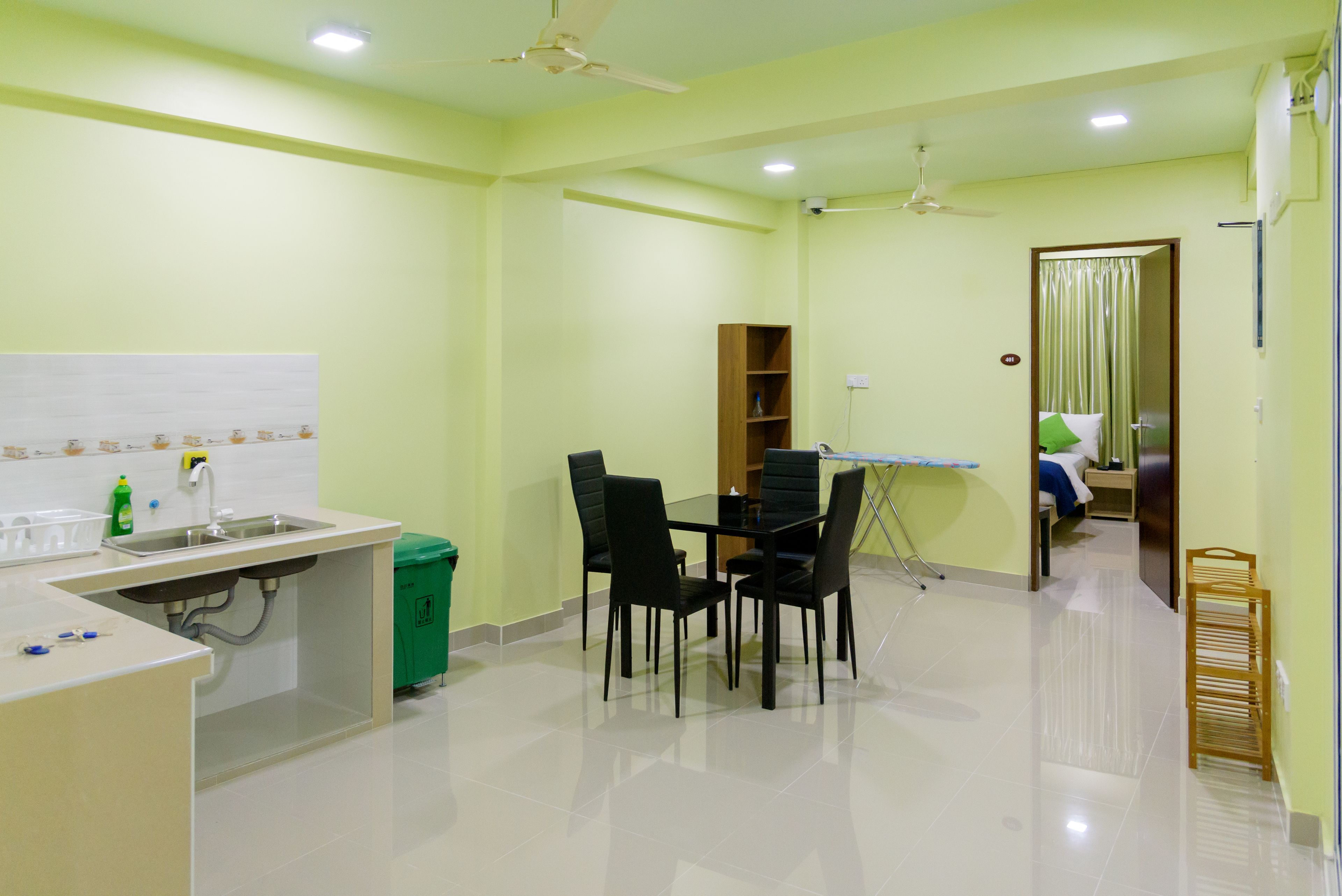 A kitchen with a dining table, chairs, a sink, and a ceiling fan.