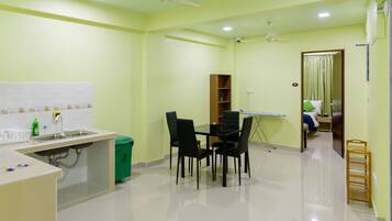 A kitchen with a dining table, chairs, a sink, and a ceiling fan.
