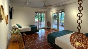 A modern bedroom with two beds, a wooden table, and a hanging light fixture. - Hacienda Hotel El Percal (Montenegro)