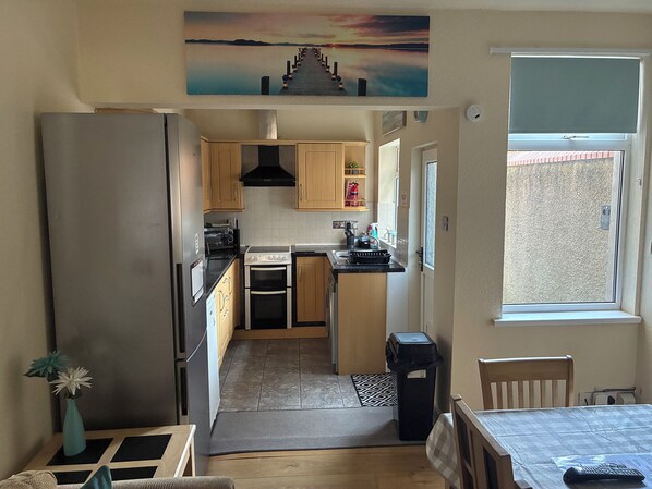A kitchen with wooden cabinets, a stove, and a refrigerator.